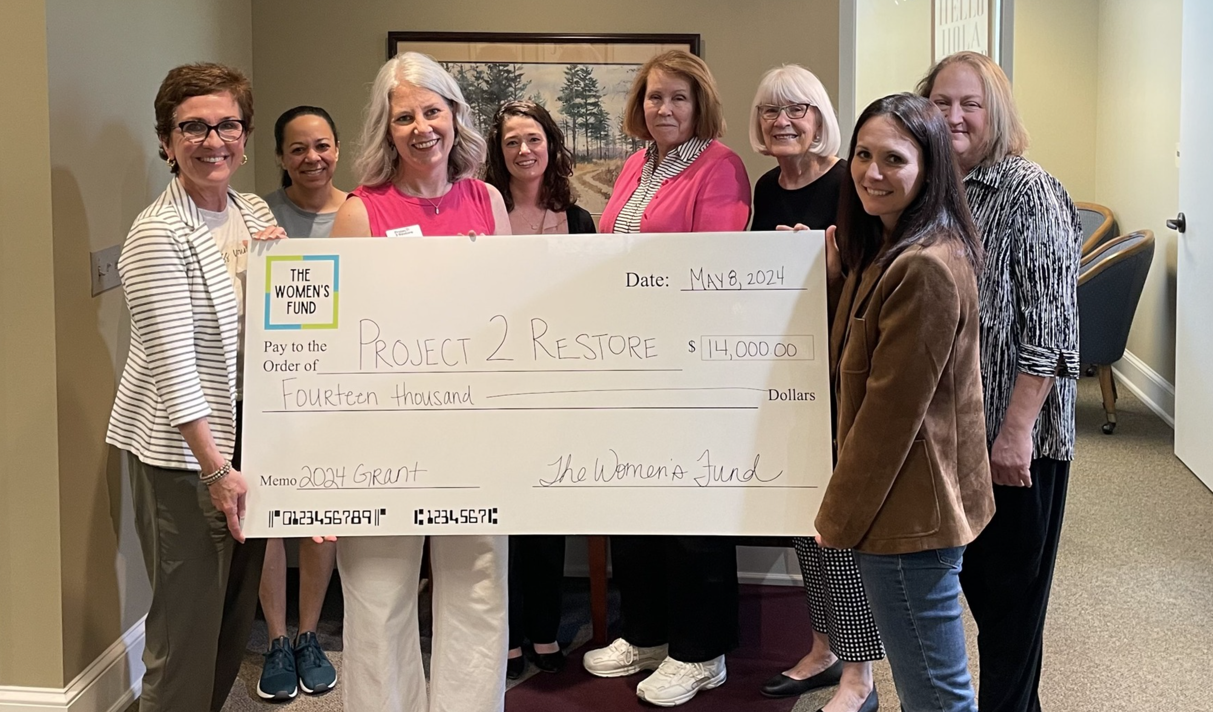 Women presenting a $14,000 grant check, illustrating grants for women in Topeka.