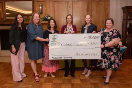 Six women presenting a $4,942 grant check, illustrating women’s philanthropy in Topeka.
