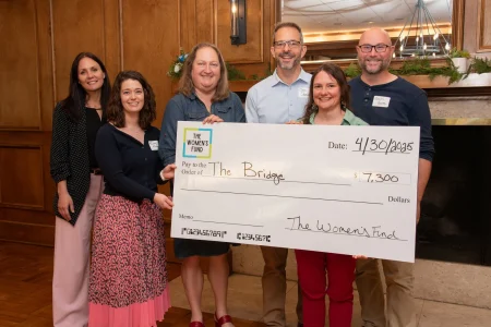 Four women and two men presenting a $7,300 grant check to The Bridge, highlighting women-led philanthropy in Topeka KS.