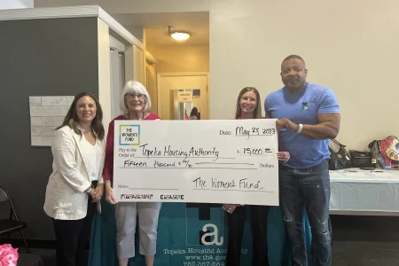 Group presenting a $15,000 grant check to the Topeka Housing Authority, showcasing women-led community impact.
