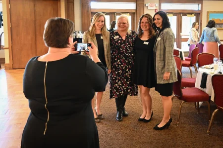 Attendees posing for a photo at a formal gathering, representing women’s collective giving group engagement.